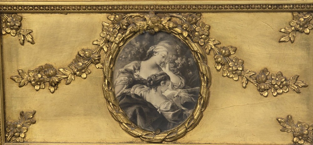 An antique French giltwood trumeau mirror featuring a tall rectangular frame topped with a carved oval painted portrait inset and floral garlands. View IV