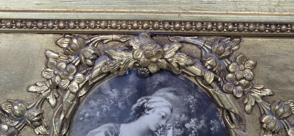 An antique French giltwood trumeau mirror featuring a tall rectangular frame topped with a carved oval painted portrait inset and floral garlands. View IX