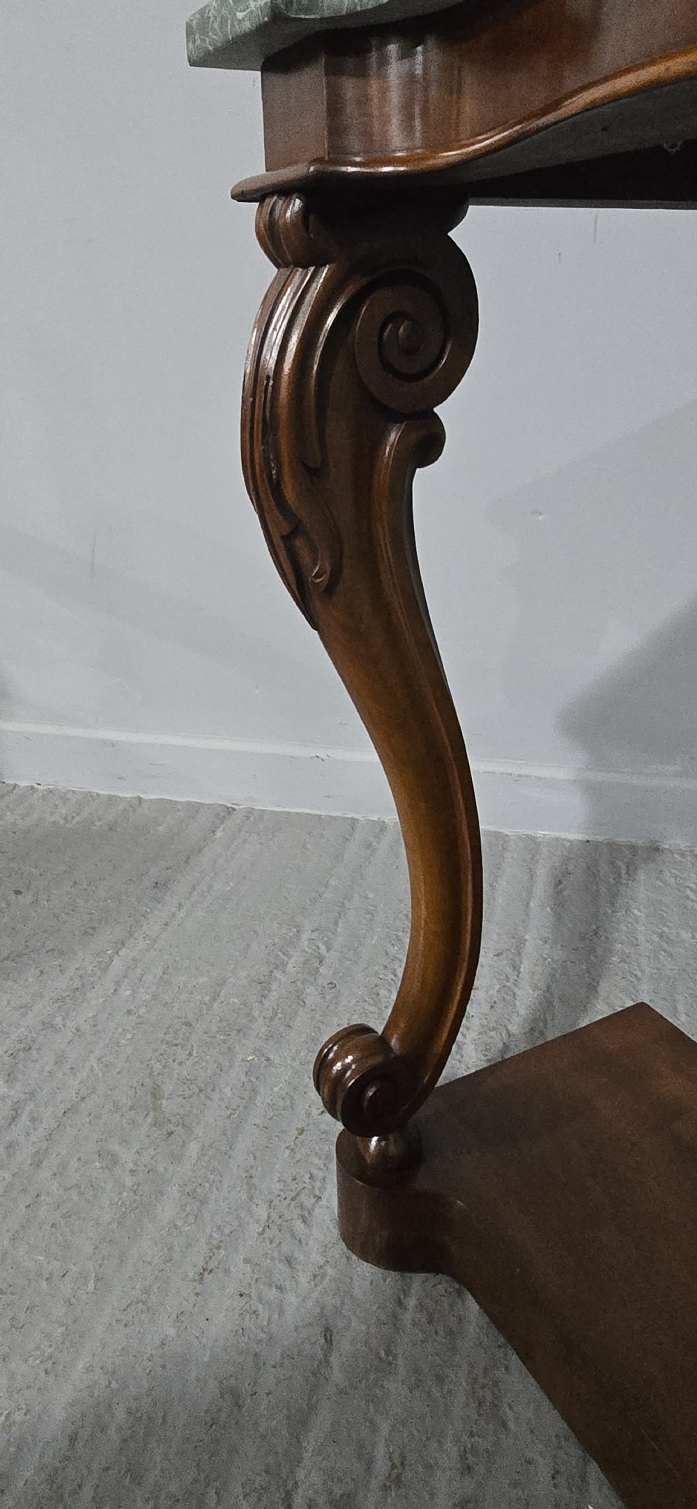 A mahogany console table featuring a green marble top supported by carved scrolled front legs on a plinth base. View VI