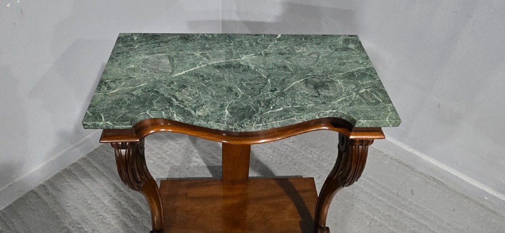A mahogany console table featuring a green marble top supported by carved scrolled front legs on a plinth base. View IX