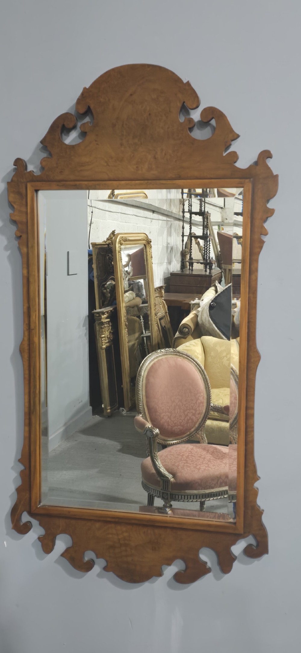 A vertical wall mirror featuring a carved burr walnut frame with scrollwork fretwork at the top crest and bottom apron. View III