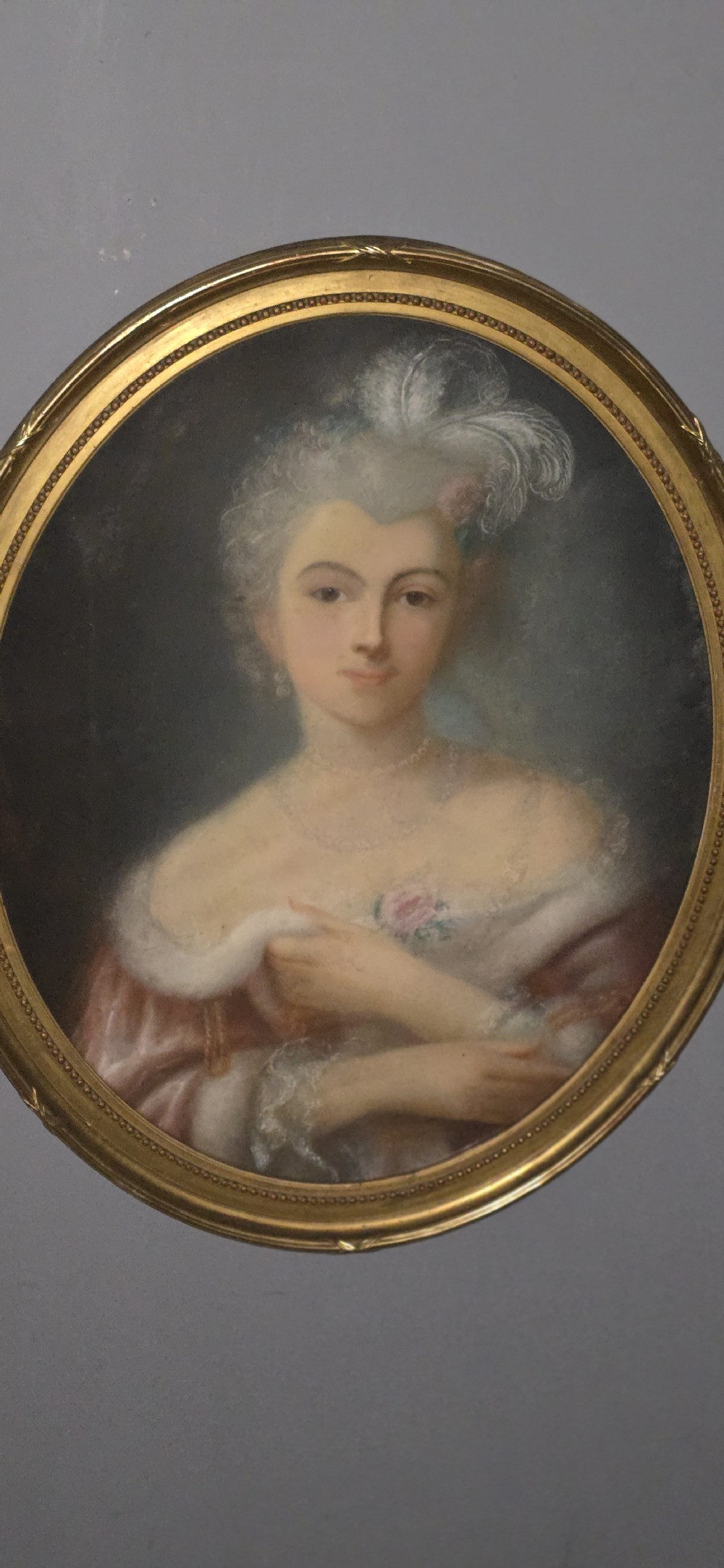 A pair of oval gilt-framed antique pastel portraits depicting two ladies in 18th-century attire. View V
