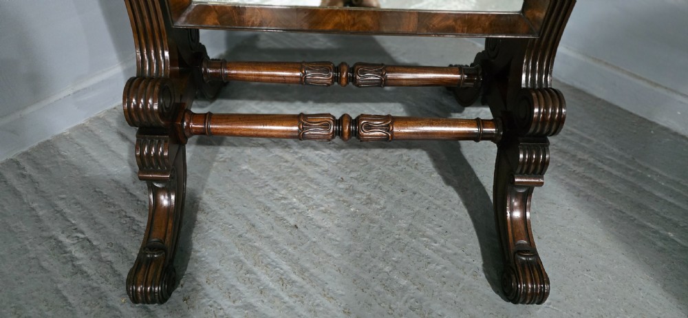 An antique Regency mahogany cheval mirror featuring a rectangular frame set between reeded upright posts on splayed legs. View V
