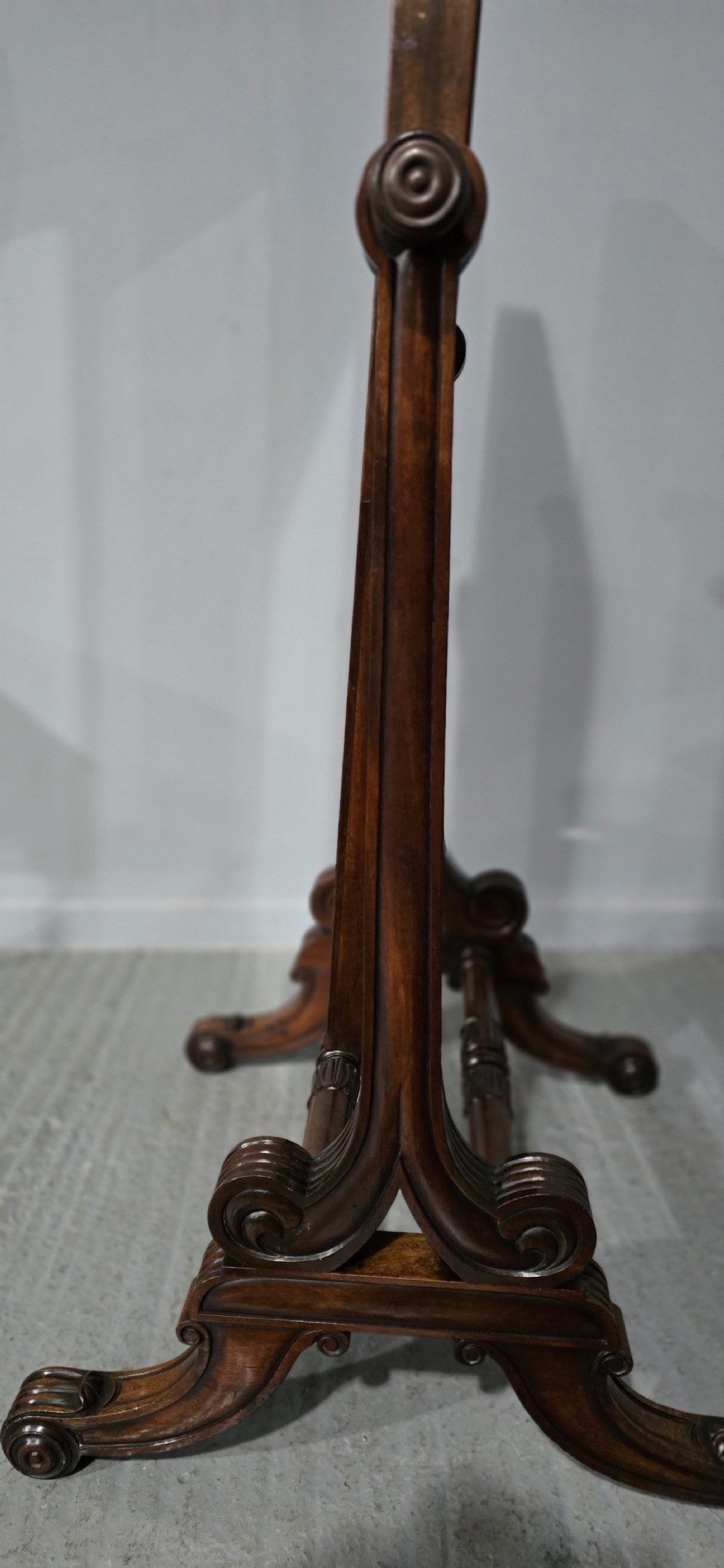An antique Regency mahogany cheval mirror featuring a rectangular frame set between reeded upright posts on splayed legs. View IX