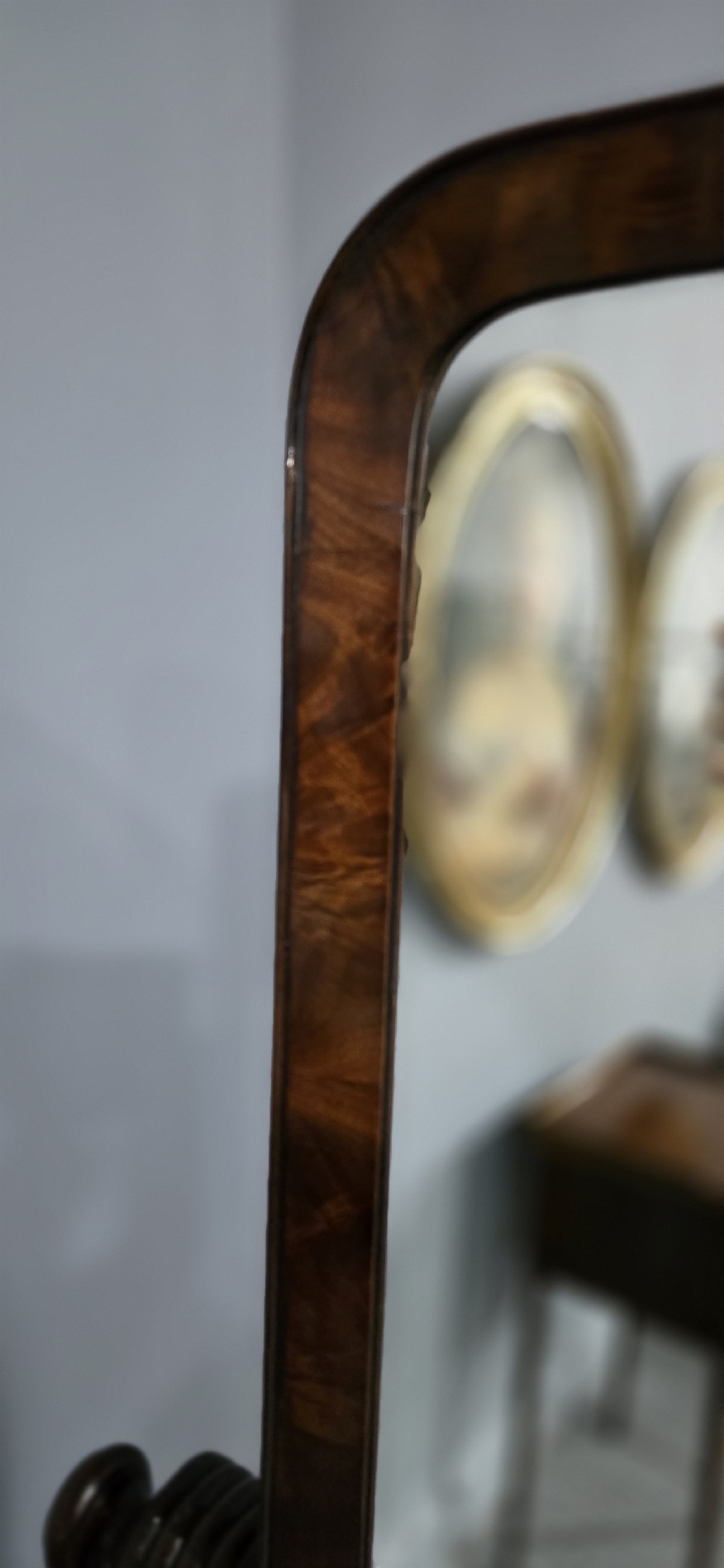 An antique Regency mahogany cheval mirror featuring a rectangular frame set between reeded upright posts on splayed legs. View XII