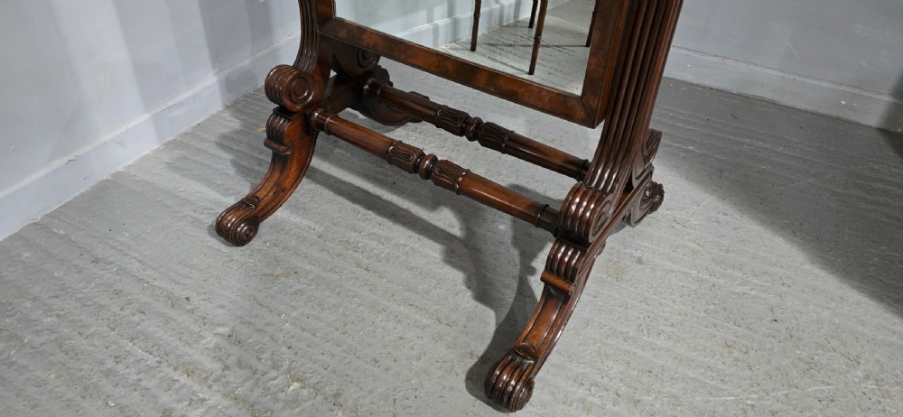An antique Regency mahogany cheval mirror featuring a rectangular frame set between reeded upright posts on splayed legs. View XV