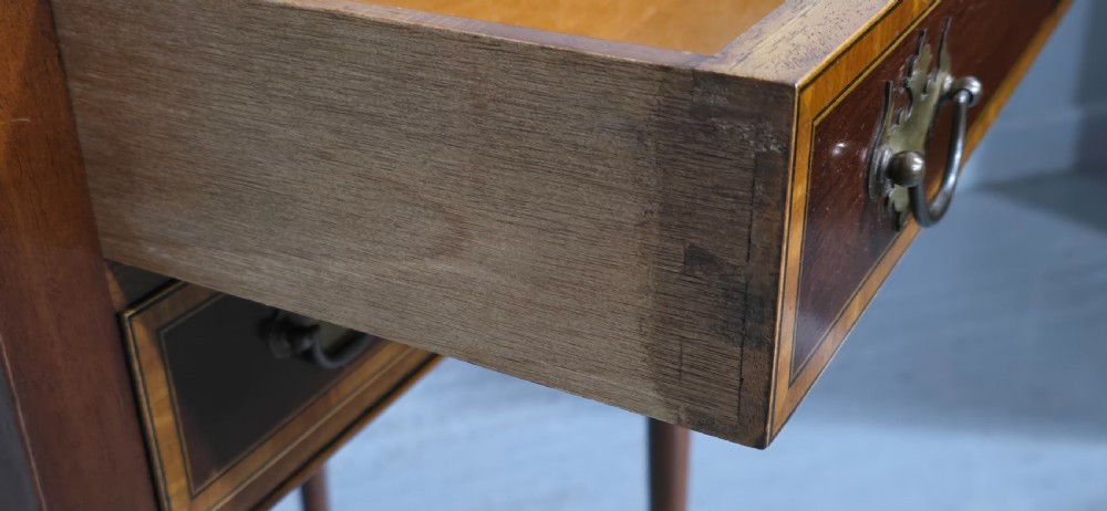 A dark mahogany side table featuring two drawers with brass batwing drop handles, crossbanded inlay borders, and slender turned legs. View VIII