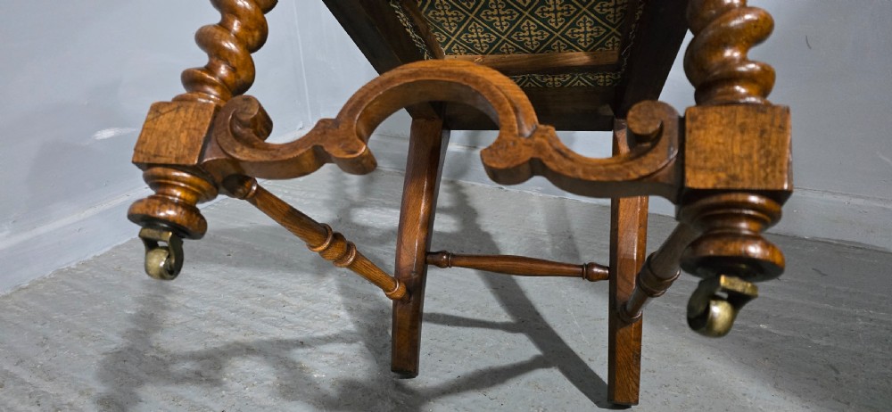 An antique walnut hall chair featuring spiral barley twist legs and supports, a carved crest with finials, and green patterned textile upholstery on the seat and backrest. View VI