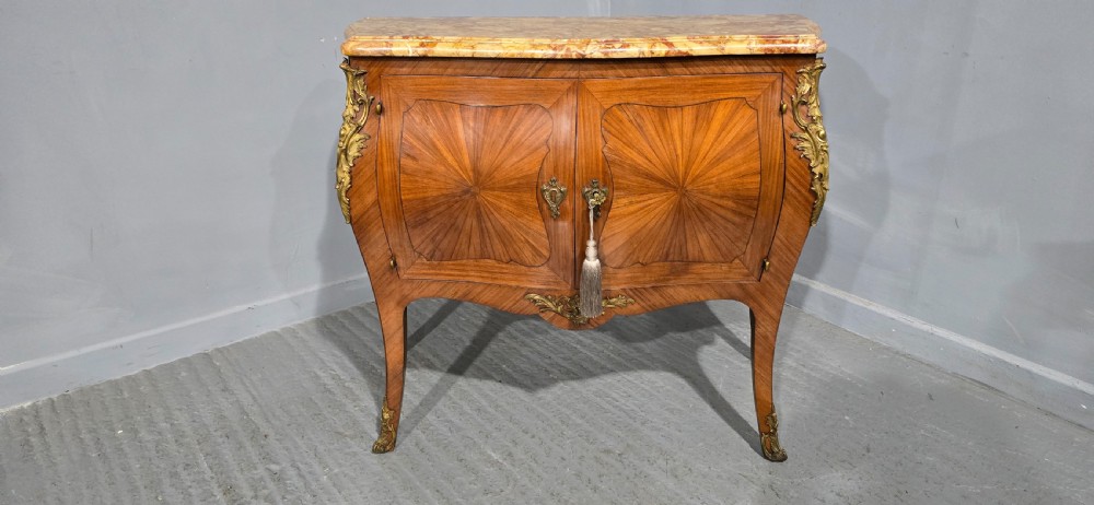 A French Louis XV style two-door cabinet featuring sunburst parquetry woodwork, a variegated marble top, cabriole legs, and ornate gilt bronze mounts. View II