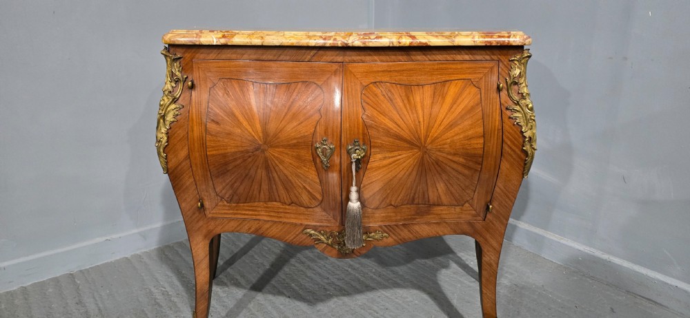 A French Louis XV style two-door cabinet featuring sunburst parquetry woodwork, a variegated marble top, cabriole legs, and ornate gilt bronze mounts. View IV
