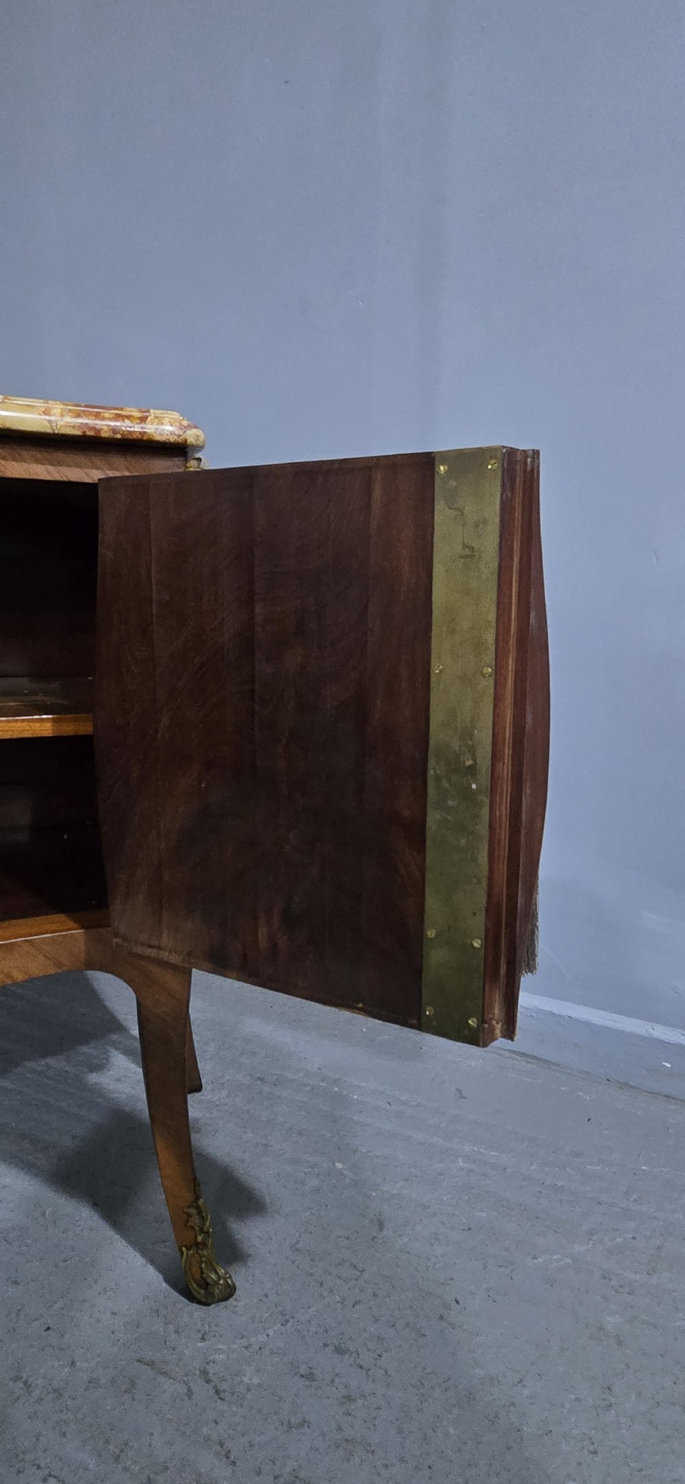 A French Louis XV style two-door cabinet featuring sunburst parquetry woodwork, a variegated marble top, cabriole legs, and ornate gilt bronze mounts. View VII