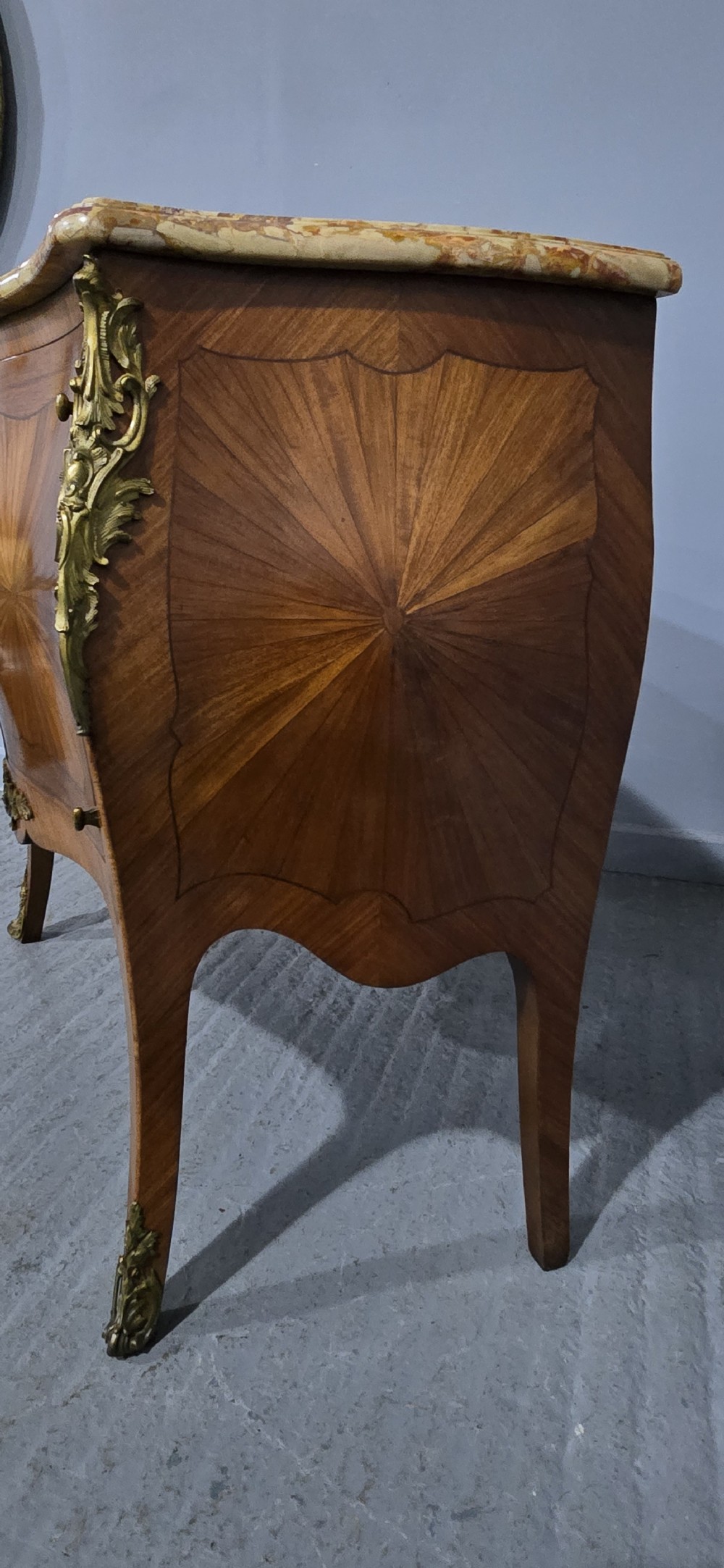 A French Louis XV style two-door cabinet featuring sunburst parquetry woodwork, a variegated marble top, cabriole legs, and ornate gilt bronze mounts. View IX