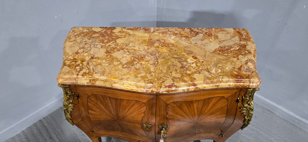A French Louis XV style two-door cabinet featuring sunburst parquetry woodwork, a variegated marble top, cabriole legs, and ornate gilt bronze mounts. View XIV