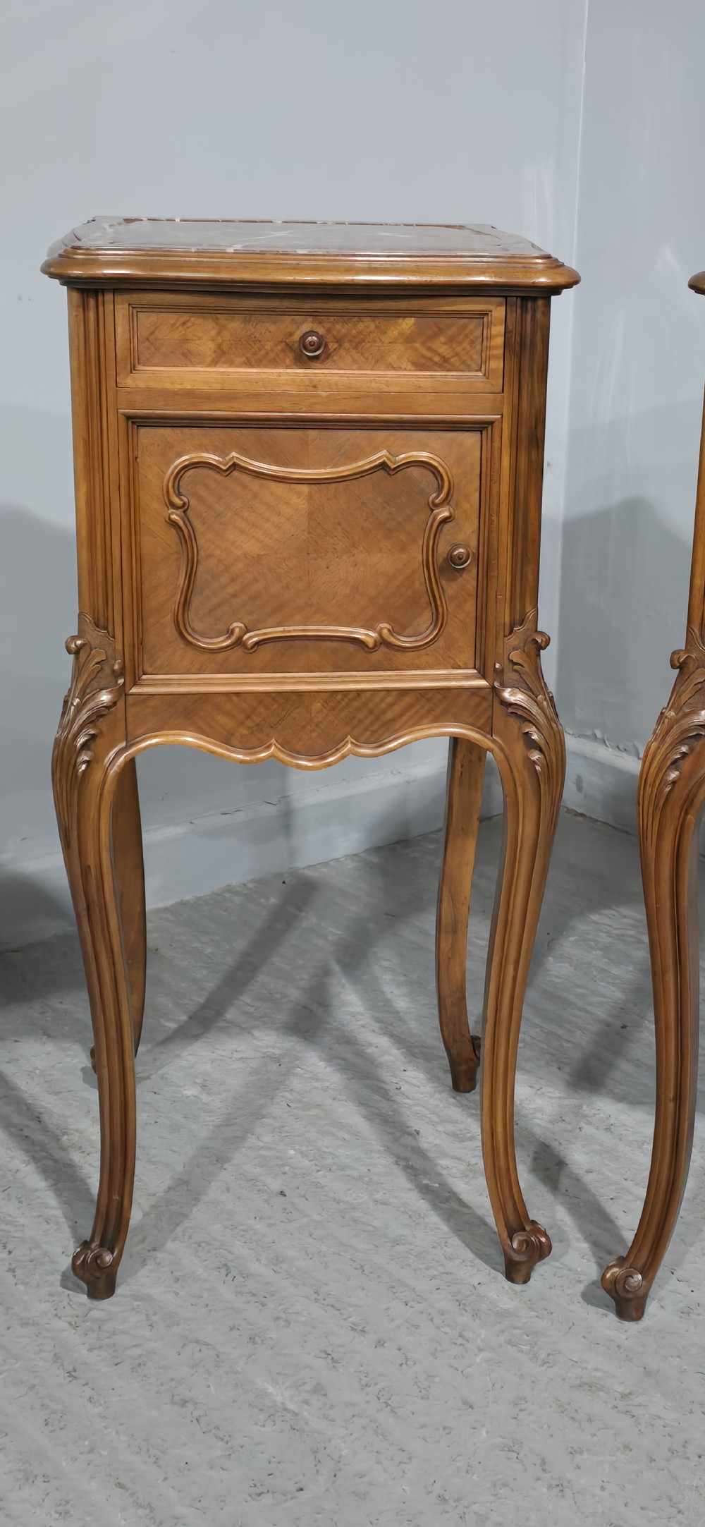 A pair of tall, slender French walnut bedside tables featuring marble tops, single upper drawers, panelled cupboard doors, and cabriole legs. View III