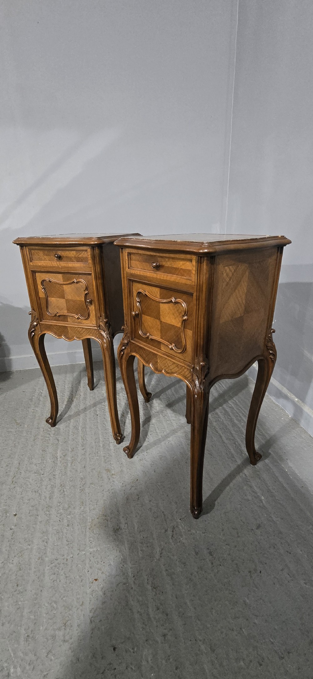 A pair of tall, slender French walnut bedside tables featuring marble tops, single upper drawers, panelled cupboard doors, and cabriole legs. View XII