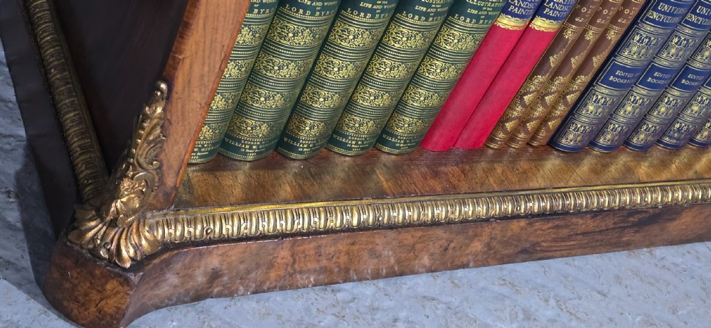 An antique open walnut library bookcase featuring three exposed shelves and decorative gilt bronze mounts along the upper apron and corner supports. View XI