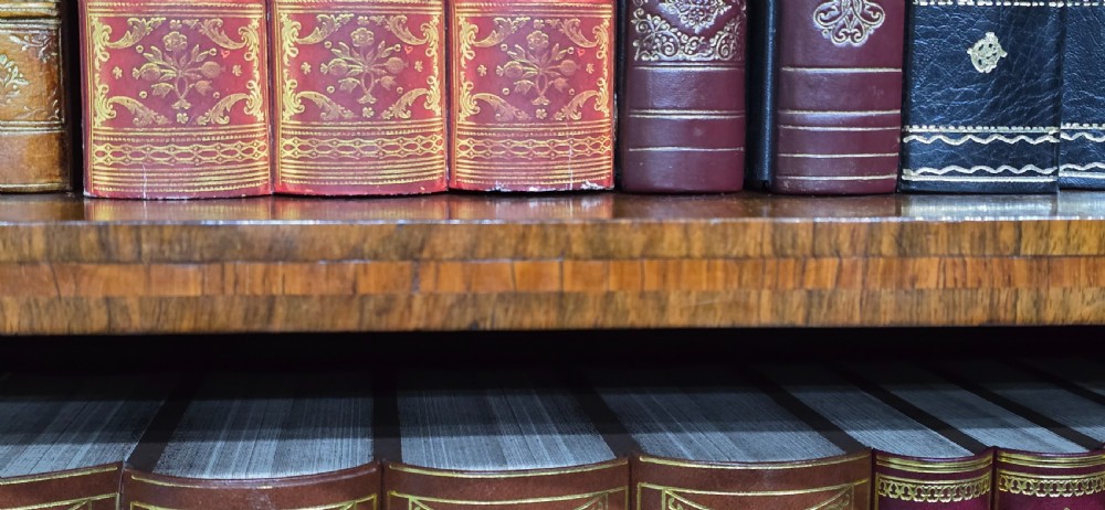 An antique open walnut library bookcase featuring three exposed shelves and decorative gilt bronze mounts along the upper apron and corner supports. View XV