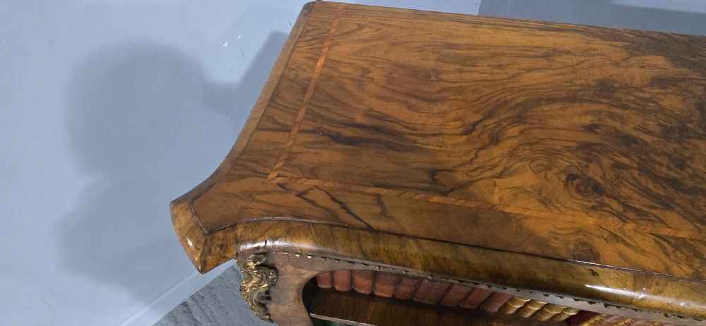 An antique open walnut library bookcase featuring three exposed shelves and decorative gilt bronze mounts along the upper apron and corner supports. View XXI