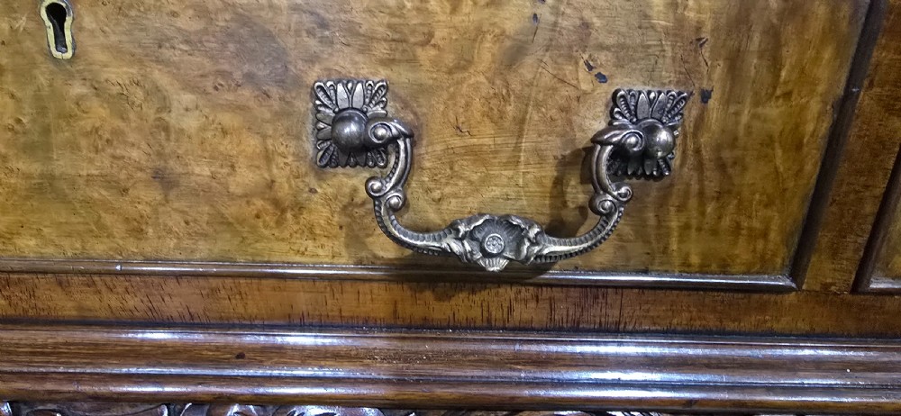 A burr walnut console table featuring two drawers with brass handles, a deeply carved apron with a central shell motif, and cabriole legs. View X