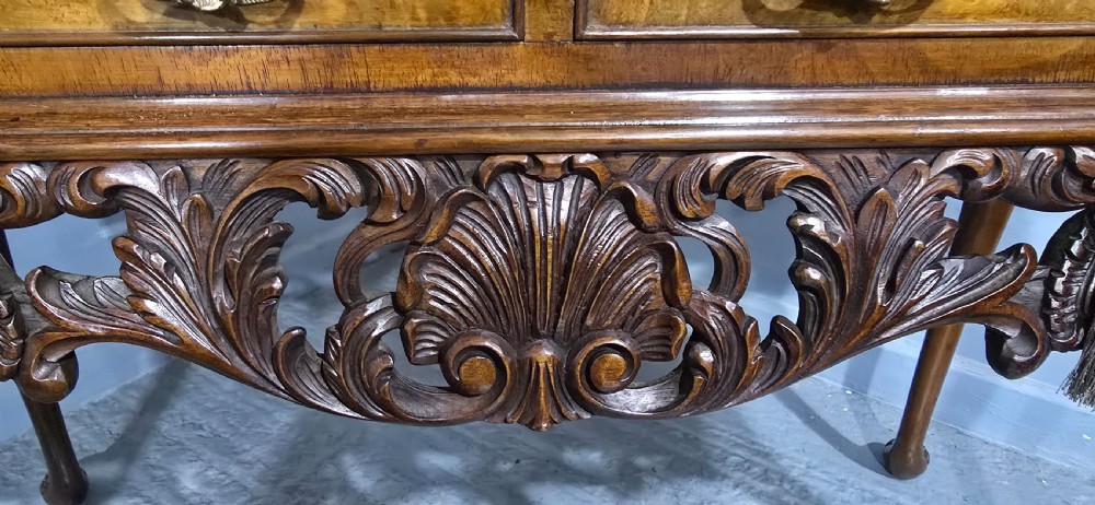 A burr walnut console table featuring two drawers with brass handles, a deeply carved apron with a central shell motif, and cabriole legs. View XII