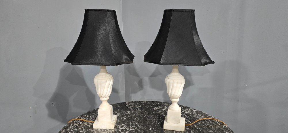 A pair of carved white marble table lamps with fluted urn bases and black flared shades. View II