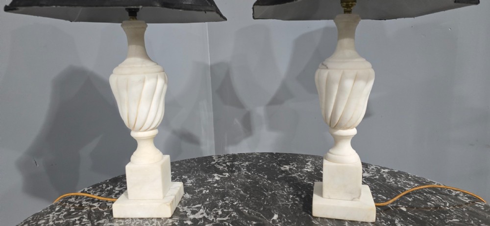 A pair of carved white marble table lamps with fluted urn bases and black flared shades. View V