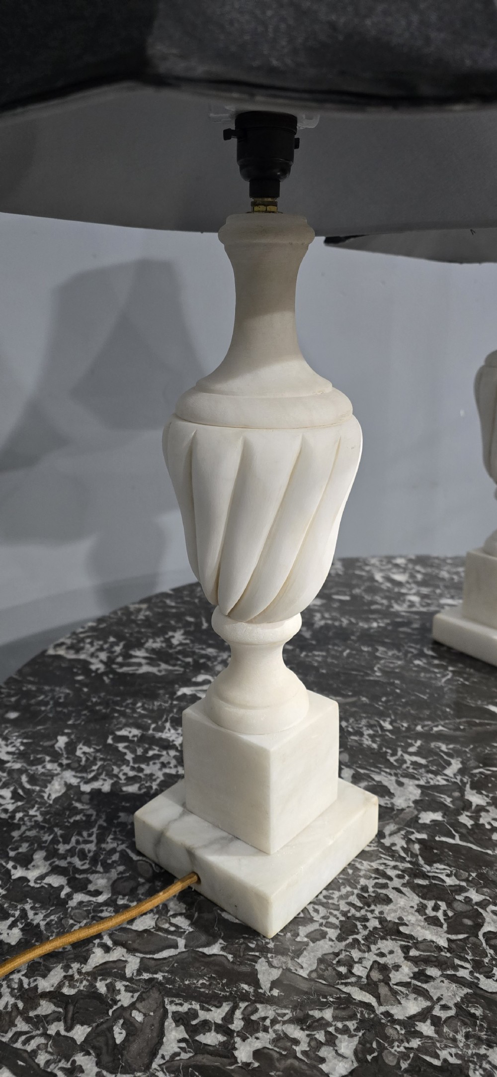A pair of carved white marble table lamps with fluted urn bases and black flared shades. View VII