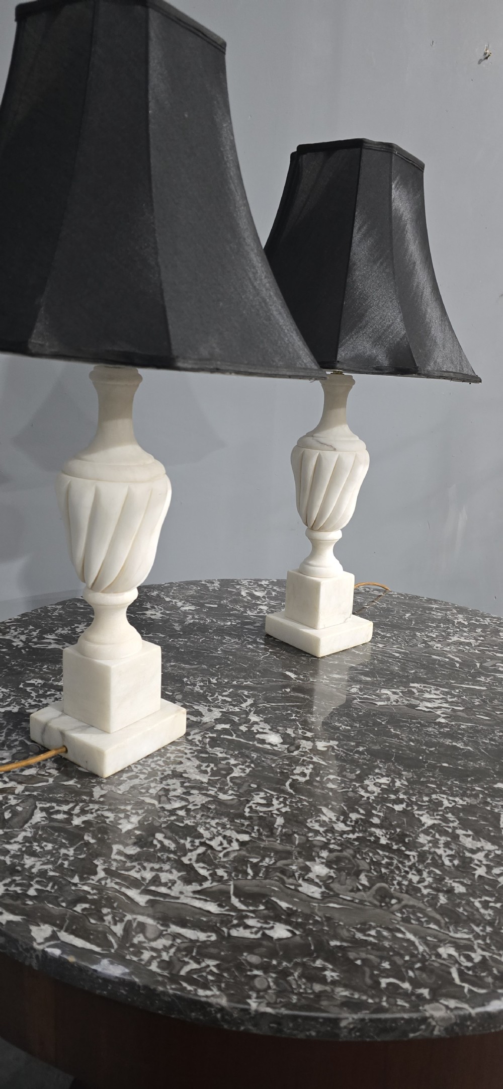 A pair of carved white marble table lamps with fluted urn bases and black flared shades. View VIII