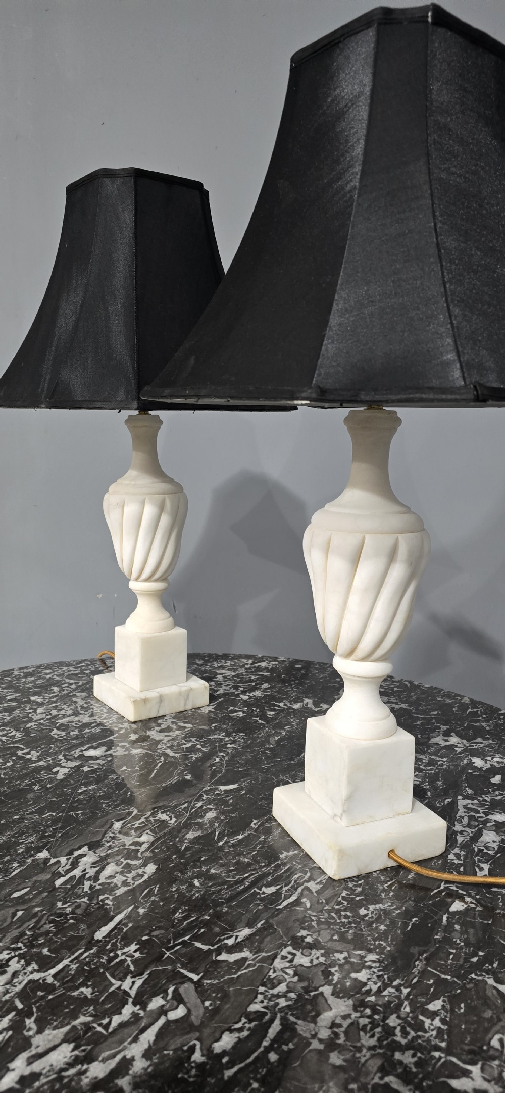 A pair of carved white marble table lamps with fluted urn bases and black flared shades. View IX