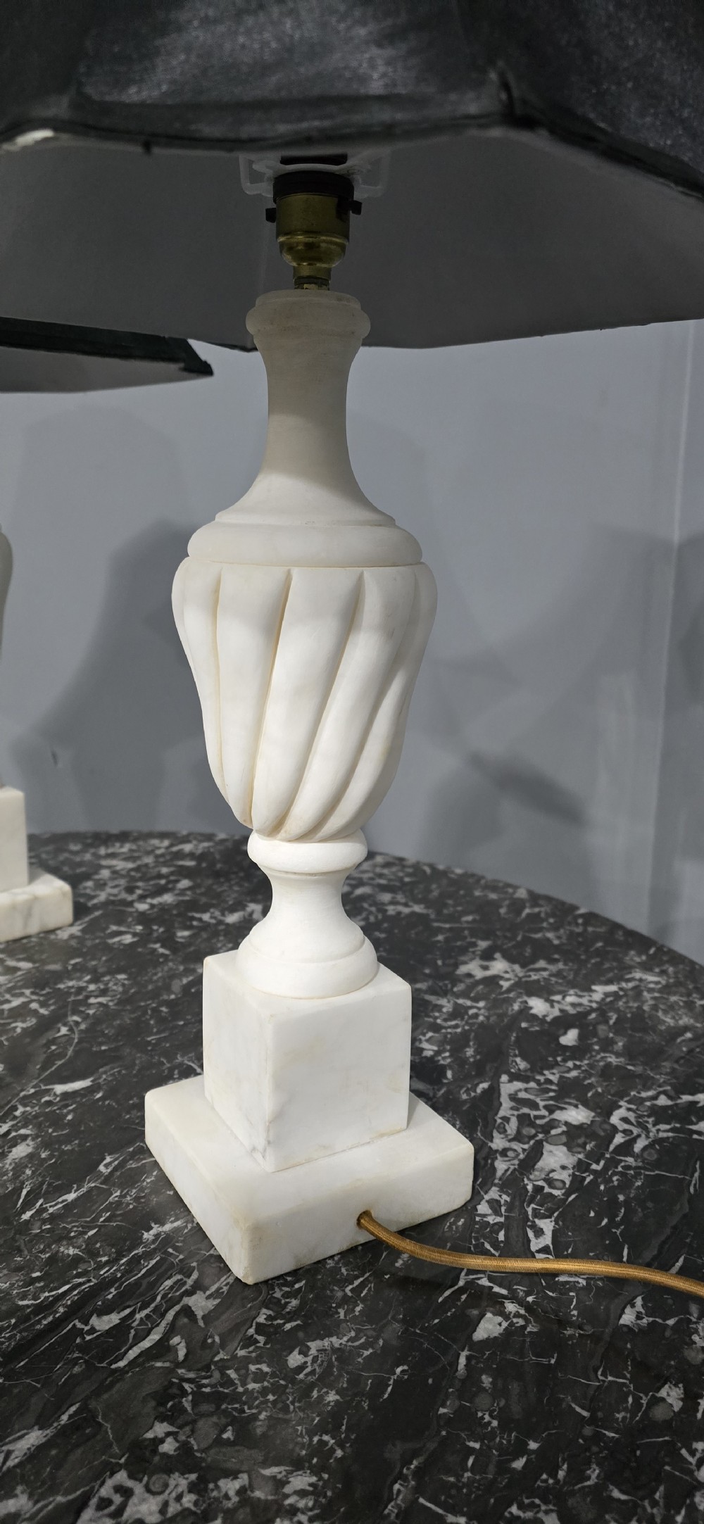 A pair of carved white marble table lamps with fluted urn bases and black flared shades. View X