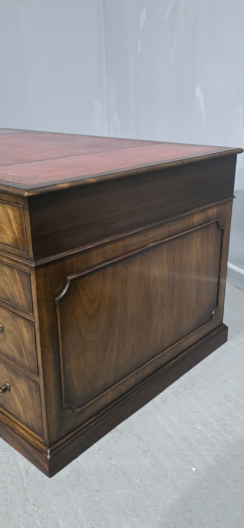 A double-pedestal mahogany partners desk featuring a leather-inset writing surface and brass swan-neck handles on multiple drawers. View IV