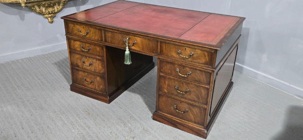 A double-pedestal mahogany partners desk featuring a leather-inset writing surface and brass swan-neck handles on multiple drawers. View VIII