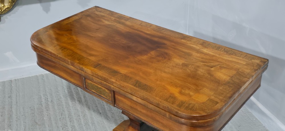 A Regency brass inlaid wooden card table featuring a fold-over top, central pedestal column, and four splayed legs with brass paw feet. View IV