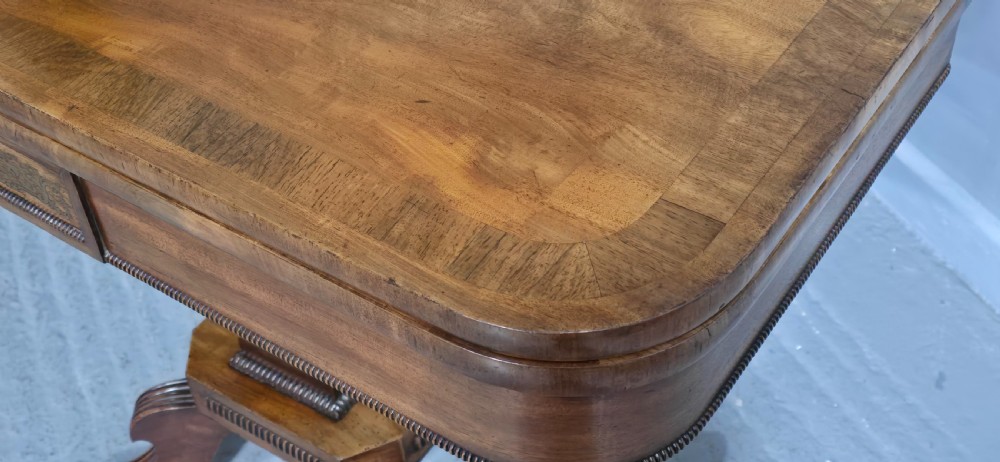 A Regency brass inlaid wooden card table featuring a fold-over top, central pedestal column, and four splayed legs with brass paw feet. View V