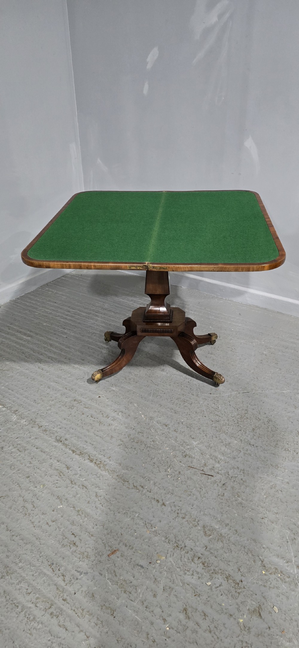 A Regency brass inlaid wooden card table featuring a fold-over top, central pedestal column, and four splayed legs with brass paw feet. View XIV