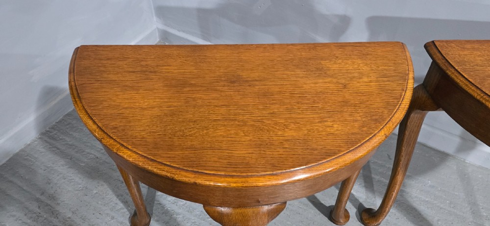 A pair of semi-circular oak console tables with smooth tops and slender cabriole legs terminating in pad feet. View II