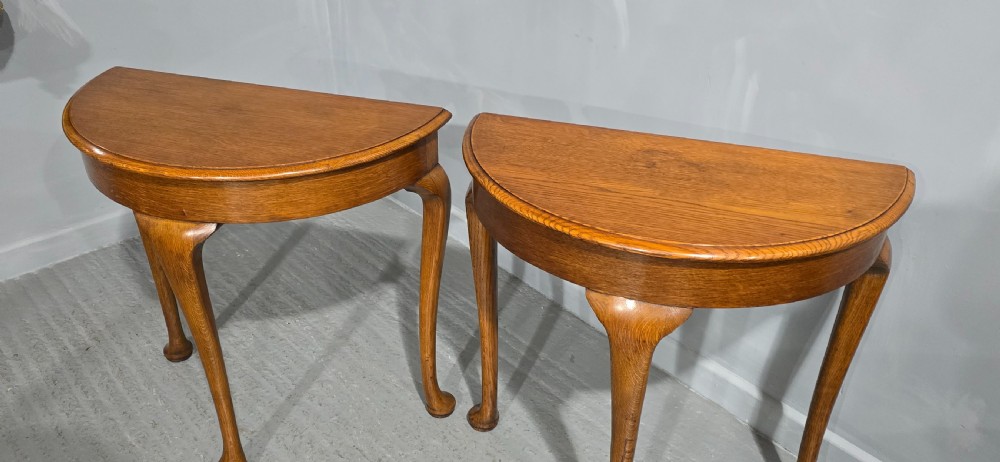 A pair of semi-circular oak console tables with smooth tops and slender cabriole legs terminating in pad feet. View IV