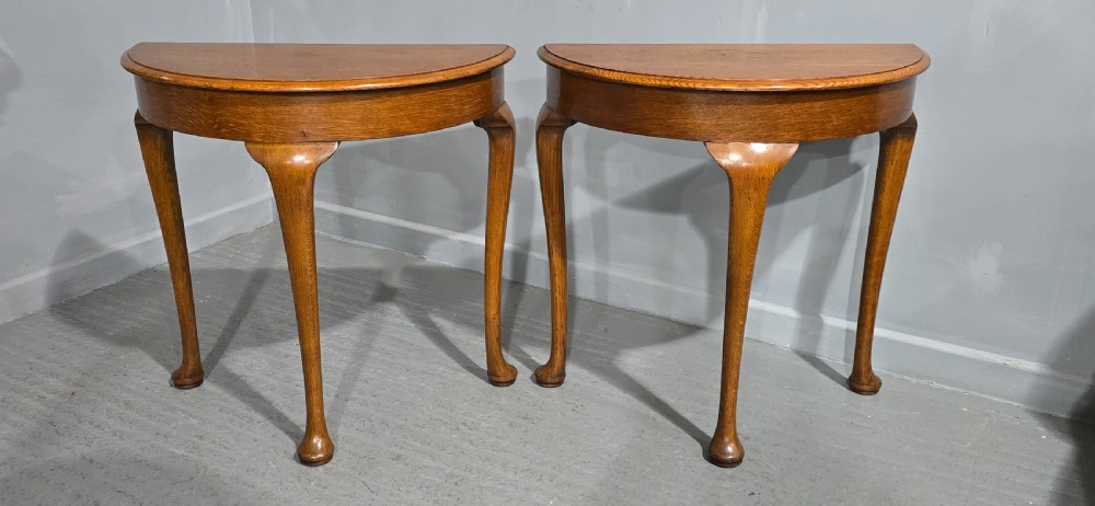 A pair of semi-circular oak console tables with smooth tops and slender cabriole legs terminating in pad feet. View X
