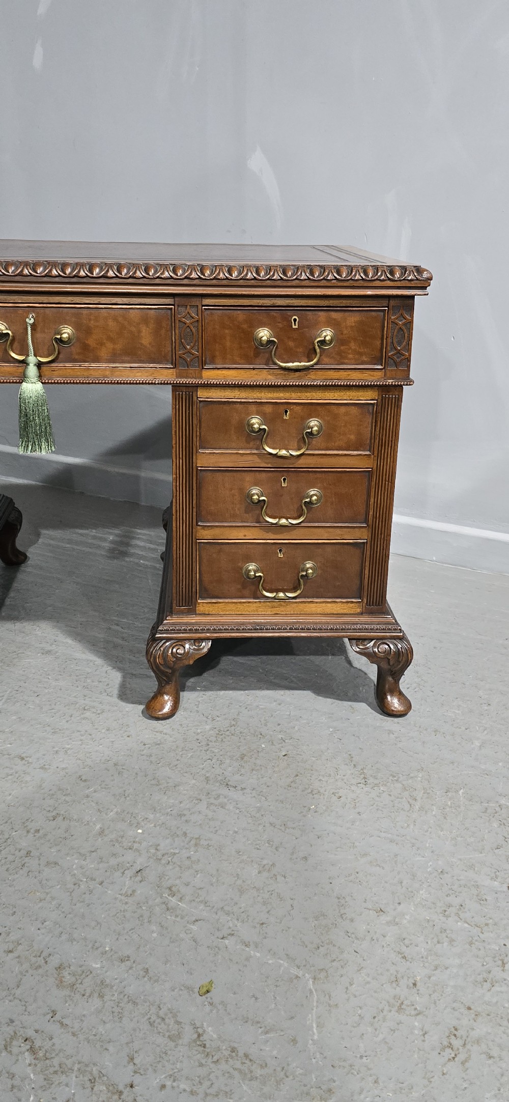 A Chippendale style mahogany pedestal desk featuring nine drawers with brass handles, a brown leather writing surface, and carved cabriole legs with ball-and-claw feet. View III