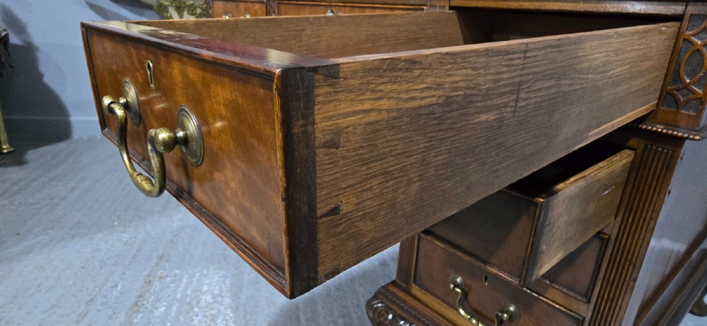 A Chippendale style mahogany pedestal desk featuring nine drawers with brass handles, a brown leather writing surface, and carved cabriole legs with ball-and-claw feet. View XI