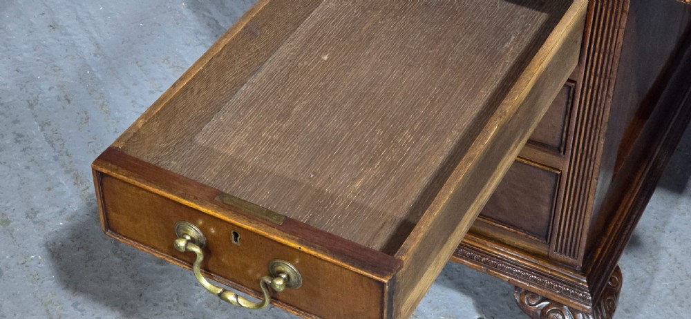 A Chippendale style mahogany pedestal desk featuring nine drawers with brass handles, a brown leather writing surface, and carved cabriole legs with ball-and-claw feet. View XIII