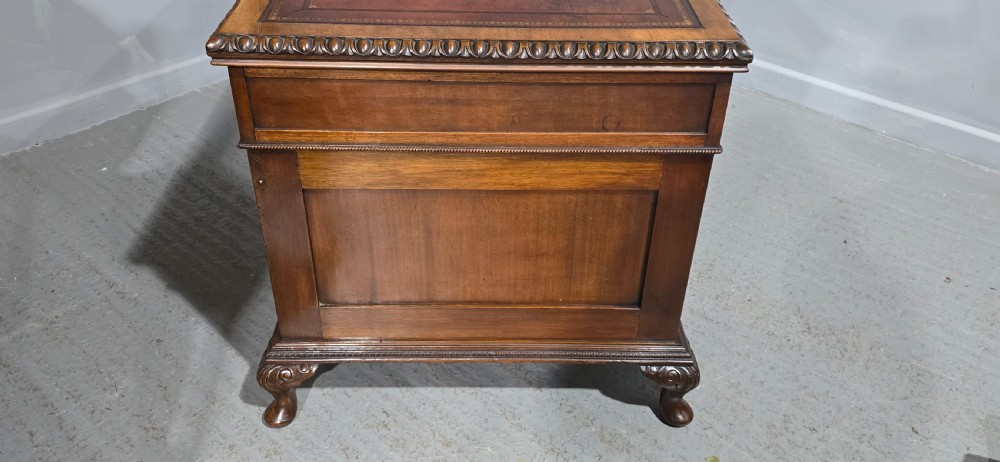A Chippendale style mahogany pedestal desk featuring nine drawers with brass handles, a brown leather writing surface, and carved cabriole legs with ball-and-claw feet. View XIX