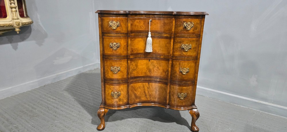 A four-drawer walnut chest of drawers featuring an inward-curving concave front, brass handles, and cabriole feet. View II