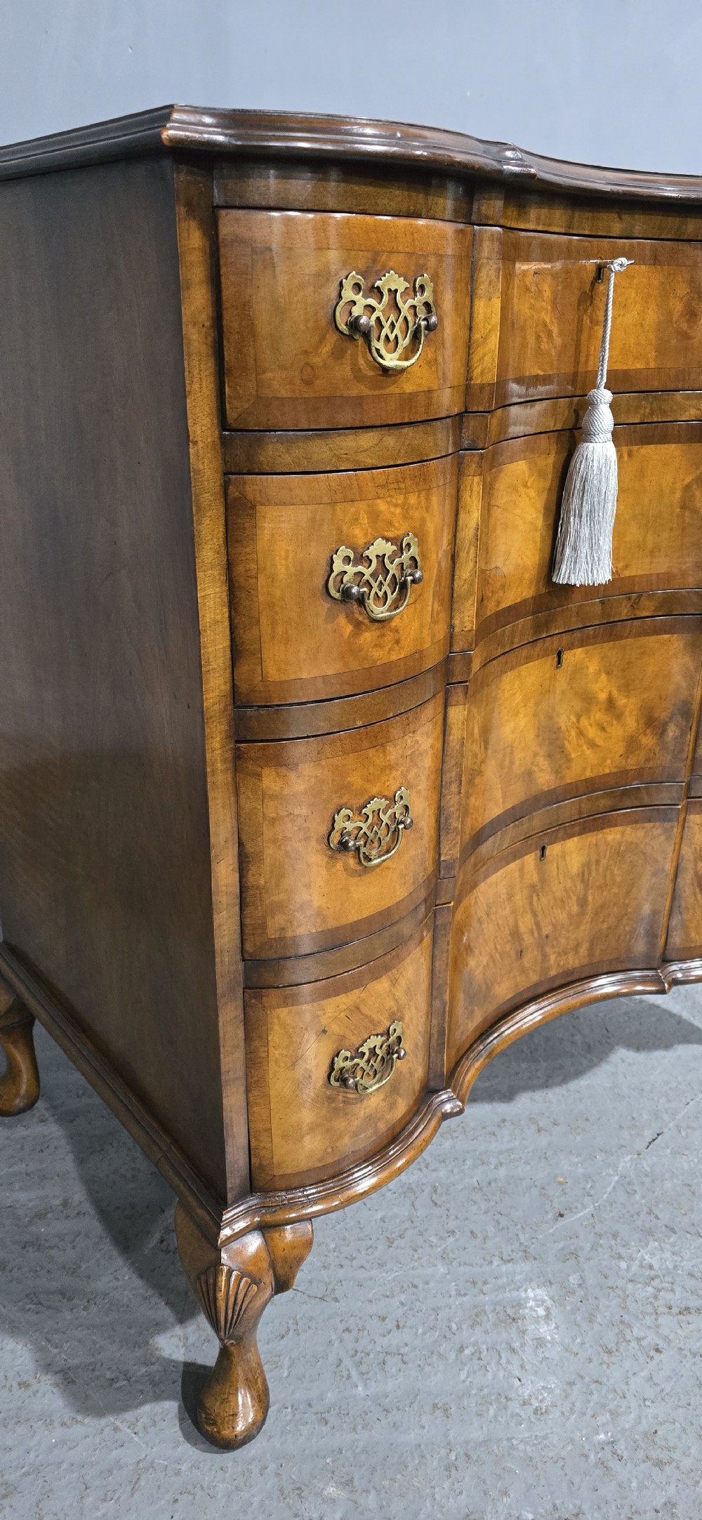 A four-drawer walnut chest of drawers featuring an inward-curving concave front, brass handles, and cabriole feet. View III