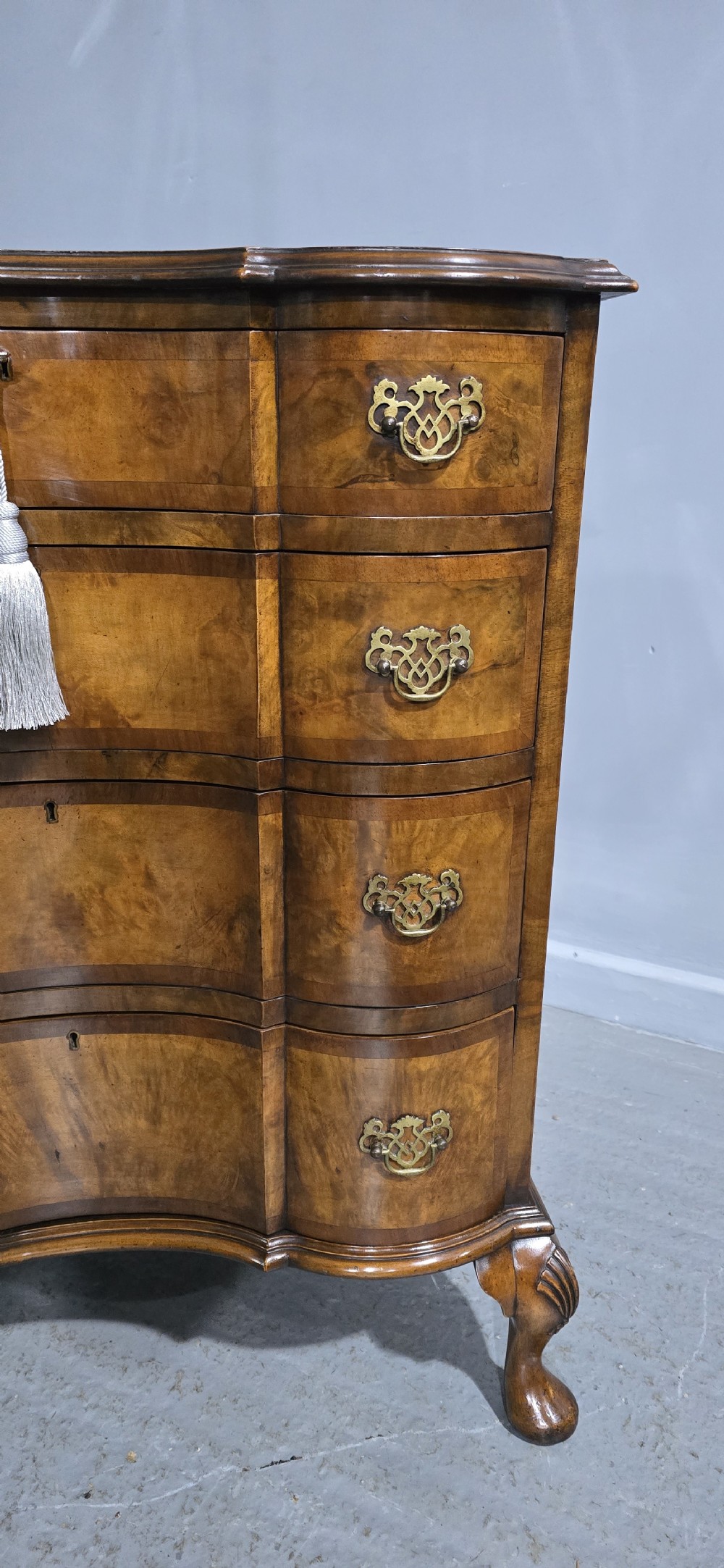 A four-drawer walnut chest of drawers featuring an inward-curving concave front, brass handles, and cabriole feet. View XII
