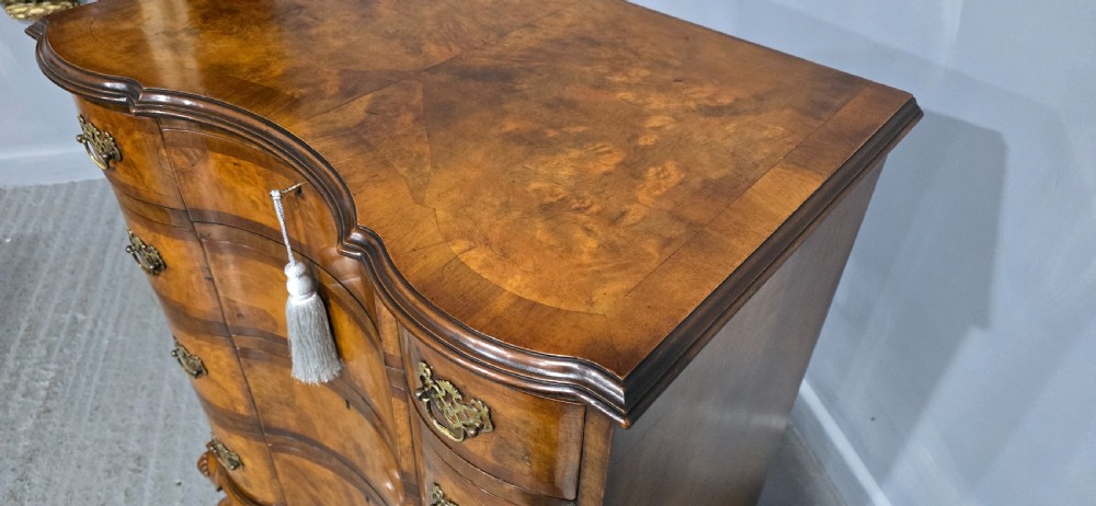 A four-drawer walnut chest of drawers featuring an inward-curving concave front, brass handles, and cabriole feet. View XIII