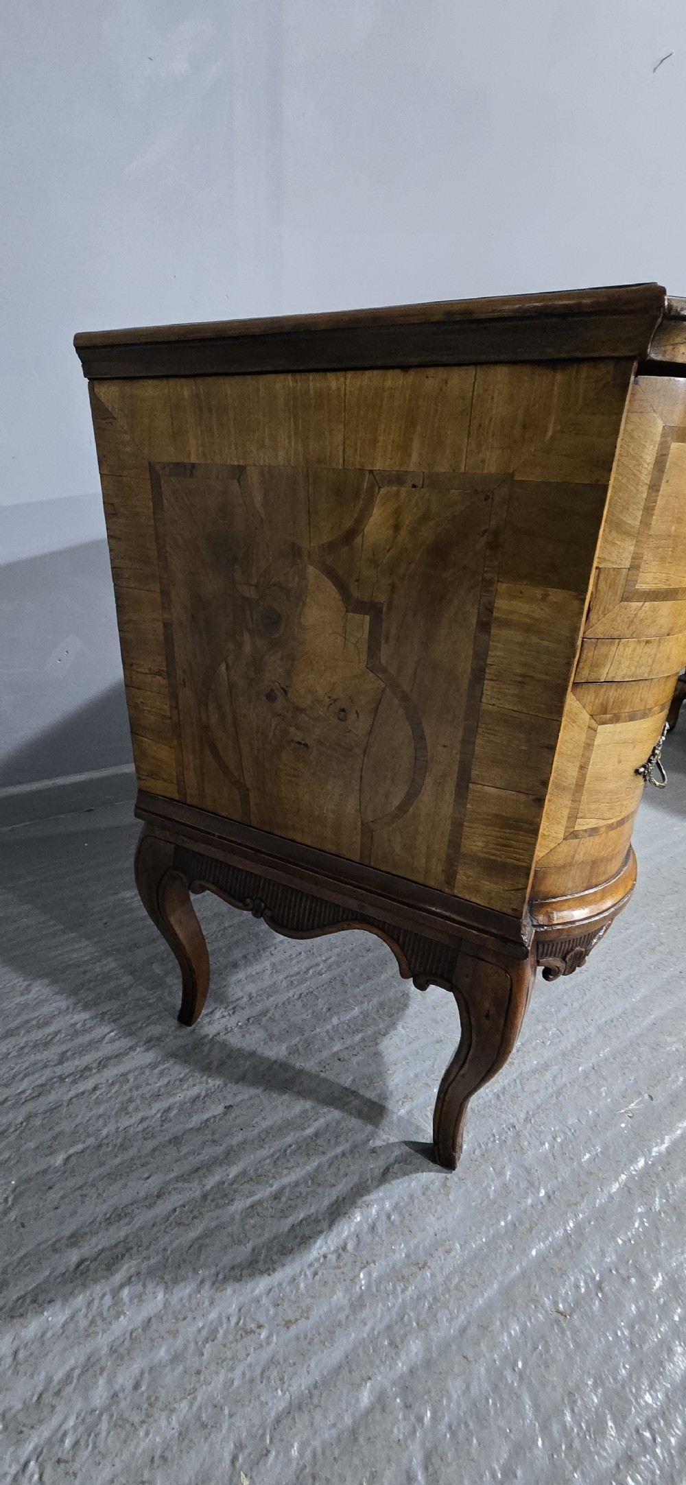 An antique walnut commode featuring two drawers with serpentine fronts, inlaid geometric banding, decorative brass handles, and carved cabriole legs. View IX