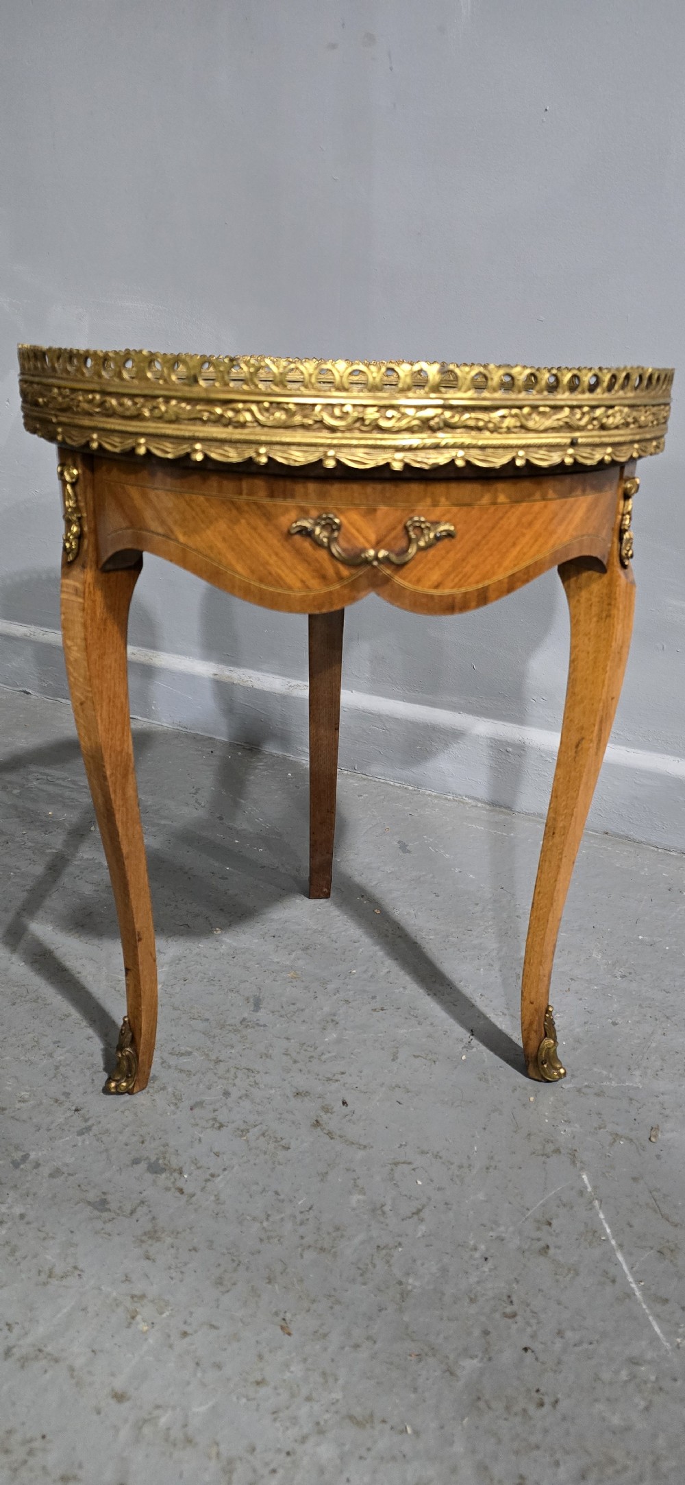 A pair of circular French kingwood side tables featuring grey marble tops, pierced brass galleries, and cabriole legs. View III