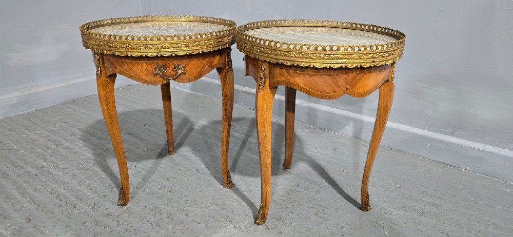 A pair of circular French kingwood side tables featuring grey marble tops, pierced brass galleries, and cabriole legs. View VI