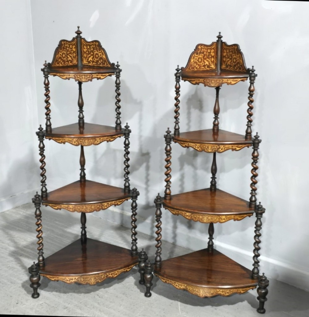 A pair of Victorian four-tier corner whatnot stands featuring intricate marquetry inlay, barley-twist columns, and decorative crestings.